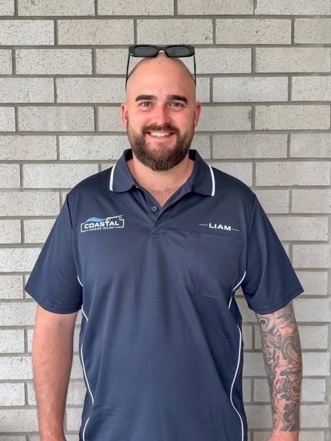 Liam Purser, owner of Coastal Power Wash, wearing his branded work shirt